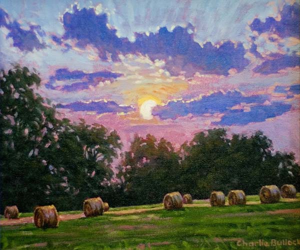 Sunset over hayrolls